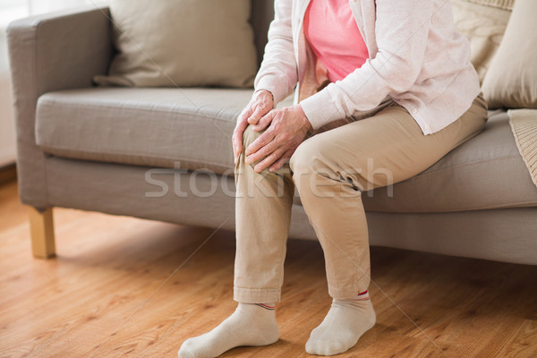 close up of senior woman with pain in leg at home Stock photo © dolgachov