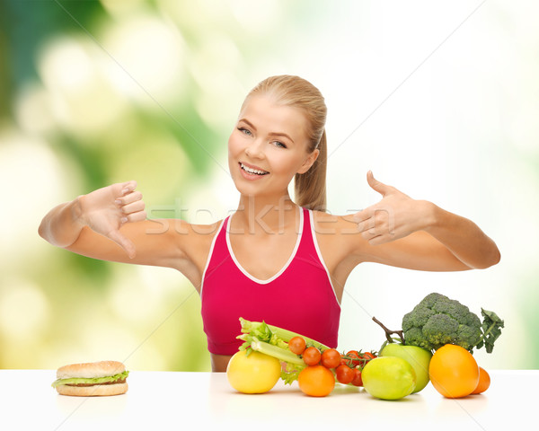 woman with fruits and hamburger comparing food Stock photo © dolgachov