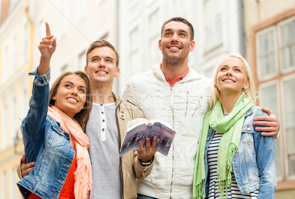 group of friends with city guide exploring town Stock photo © dolgachov