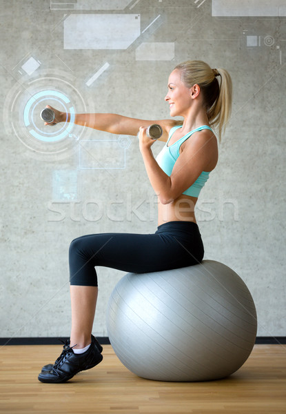 smiling woman with dumbbells and exercise ball Stock photo © dolgachov