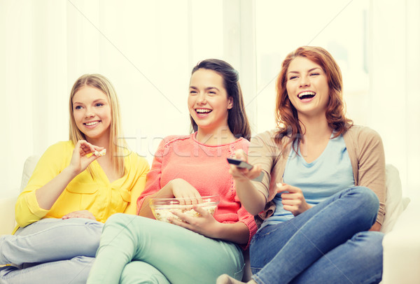 three smiling teenage girl watching tv at home Stock photo © dolgachov