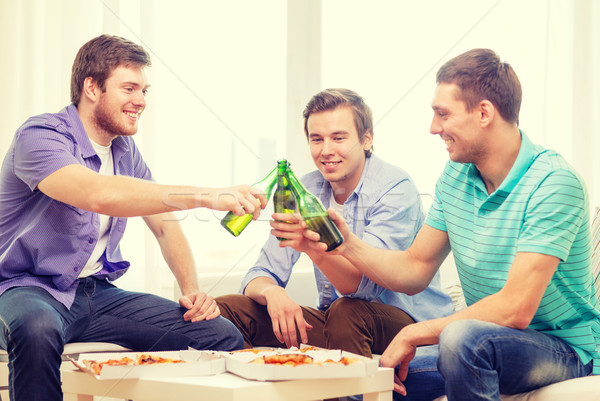 smiling friends with beer and pizza hanging out Stock photo © dolgachov