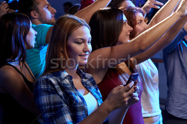 woman with smartphone texting message at concert Stock photo © dolgachov