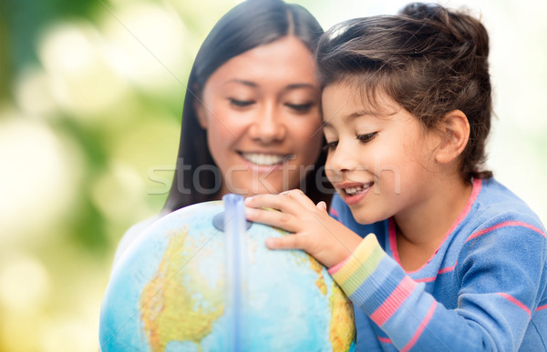 happy mother and daughter with globe Stock photo © dolgachov