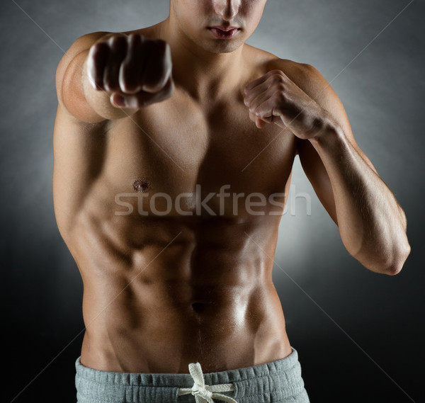 young man on fighting stand over black background Stock photo © dolgachov