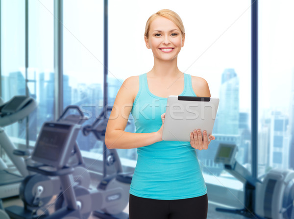 smiling sporty woman with tablet pc in gym Stock photo © dolgachov