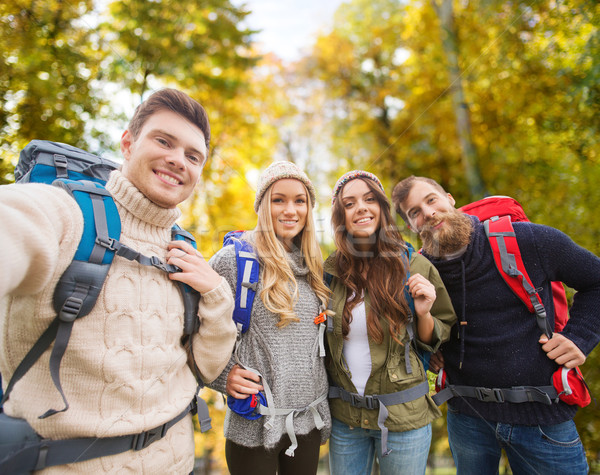 group of smiling friends with backpacks hiking Stock photo © dolgachov