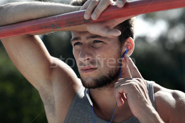 young man with earphones and horizontal bar Stock photo © dolgachov