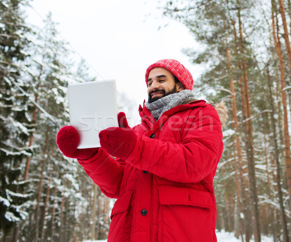 happy man with tablet pc in winter forest Stock photo © dolgachov