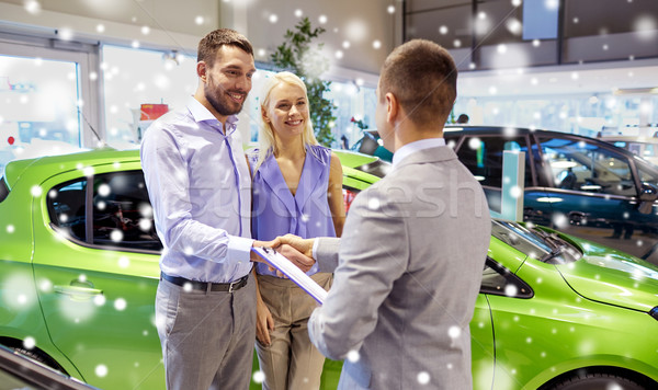 Stock photo: happy couple with car dealer in auto show or salon