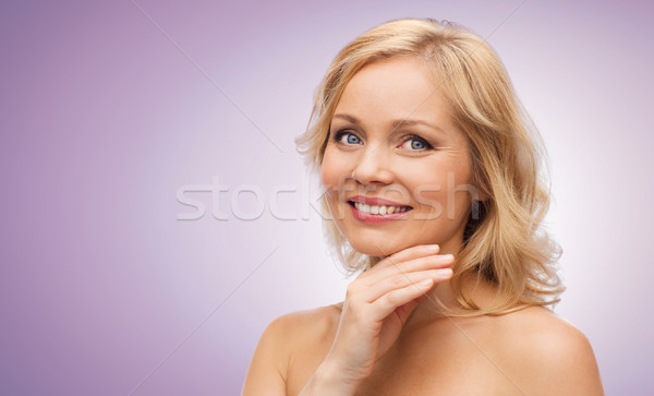 Stock photo: smiling woman with bare shoulders touching face