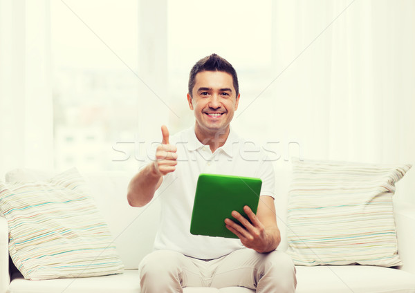 Stock photo: smiling man working with tablet pc at home