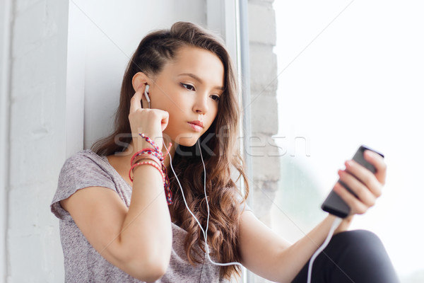 teenage girl with smartphone and earphones Stock photo © dolgachov