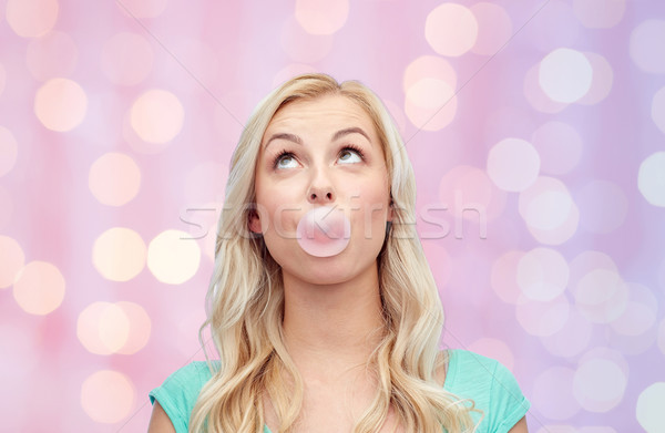 Stock photo: happy young woman or teenage girl chewing gum