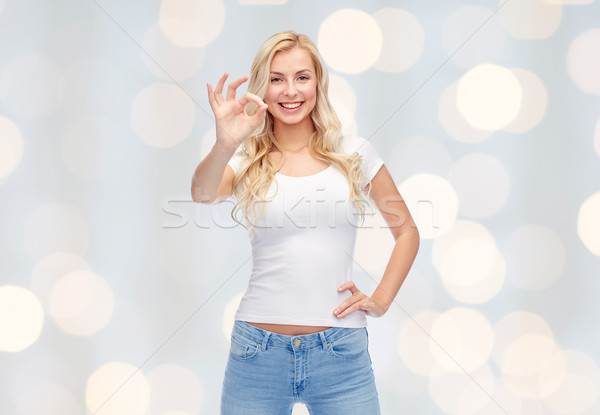 Boldog fiatal nő fehér póló mutat ok Stock fotó © dolgachov