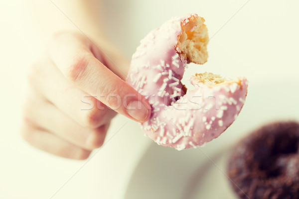 close up of hand holding bitten glazed donut Stock photo © dolgachov