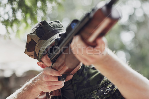 soldier or hunter shooting with gun in forest Stock photo © dolgachov