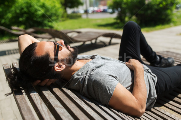 happy man lying on street bench or sun bed  Stock photo © dolgachov