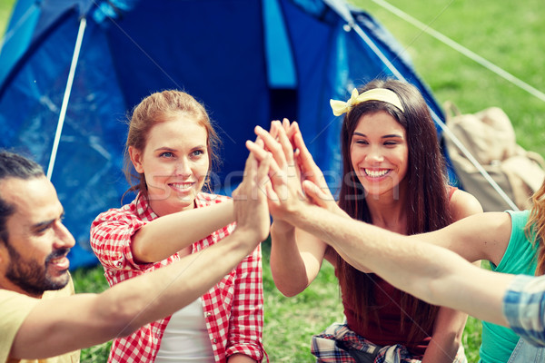 happy friends making high five at camping Stock photo © dolgachov