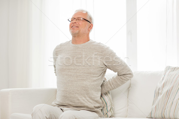 unhappy senior man suffering from backache at home Stock photo © dolgachov