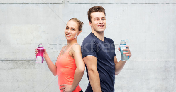 sportive man and woman with water bottles Stock photo © dolgachov