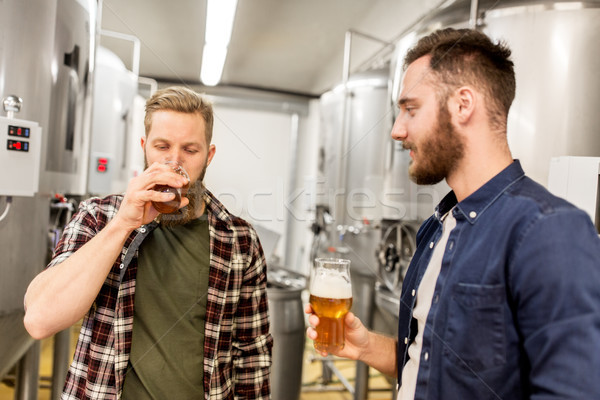 men drinking and testing craft beer at brewery Stock photo © dolgachov