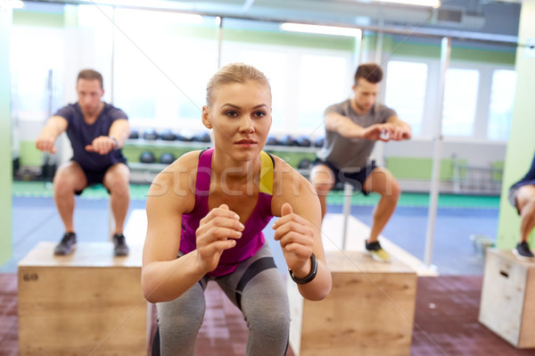 group of people doing box jumps exercise in gym Stock photo © dolgachov