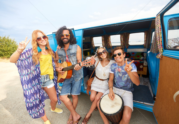 happy hippie friends playing music in minivan Stock photo © dolgachov