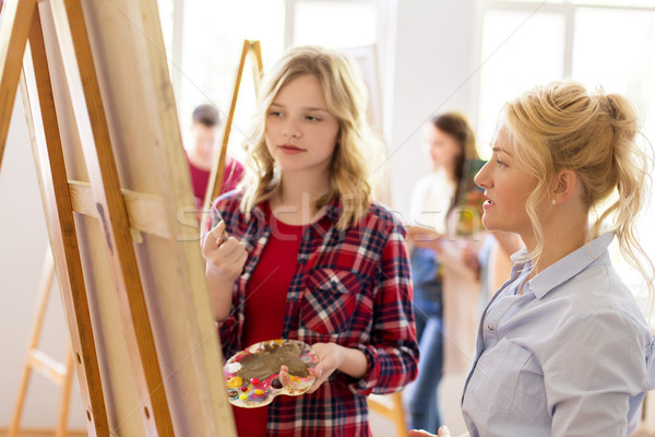 artists discussing painting on easel at art school Stock photo © dolgachov
