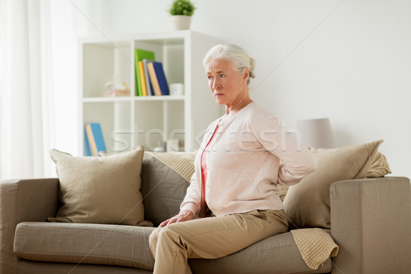 senior woman suffering from pain in back at home Stock photo © dolgachov