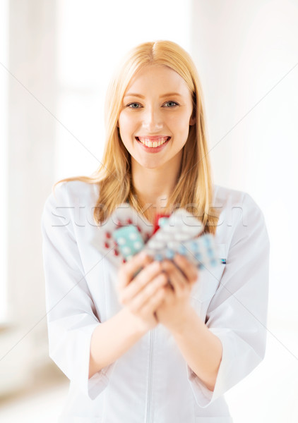 young female doctor with pack of pills Stock photo © dolgachov