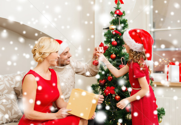 smiling family decorating christmas tree Stock photo © dolgachov