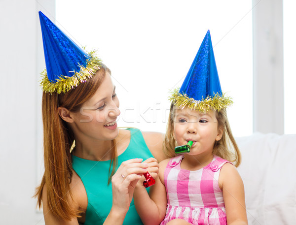 Stock photo: mother and daughter in blue hats with favor horns
