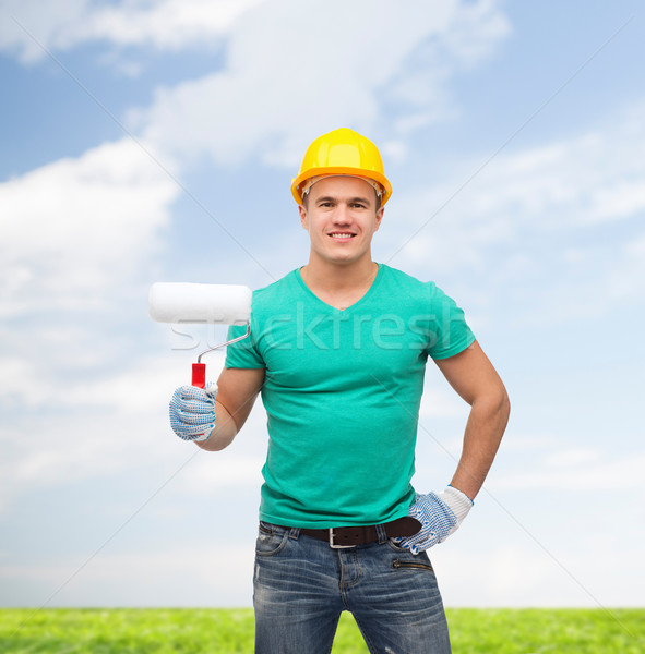 smiling manual worker in helmet with paint roller Stock photo © dolgachov