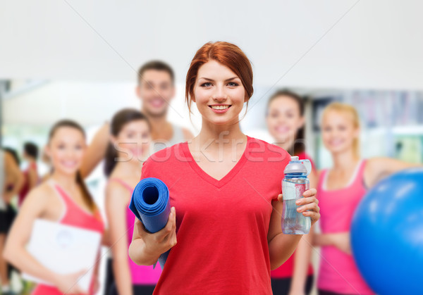 smiling girl with bottle of water after exercising Stock photo © dolgachov