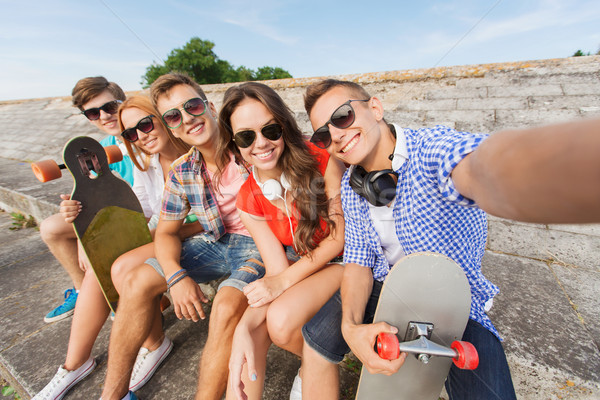 group of smiling friends with smartphone outdoors Stock photo © dolgachov