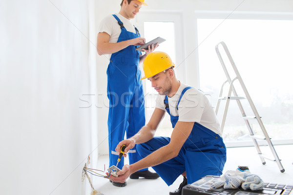 builders with tablet pc and equipment indoors Stock photo © dolgachov