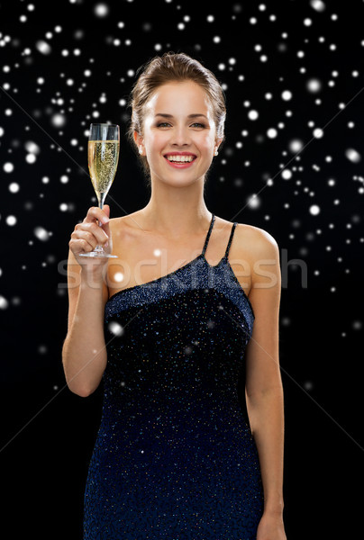 Stock photo: smiling woman holding glass of sparkling wine