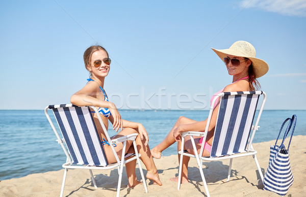 happy women sunbathing in lounges on beach Stock photo © dolgachov