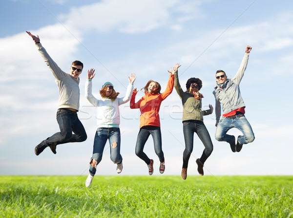 smiling friends in sunglasses jumping high Stock photo © dolgachov