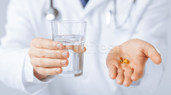 Orvos kezek kapszula üveg víz kép Stock fotó © dolgachov