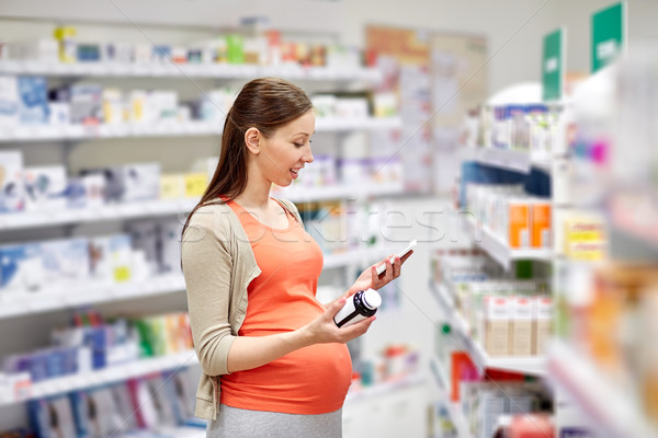 happy pregnant woman with smartphone at pharmacy Stock photo © dolgachov