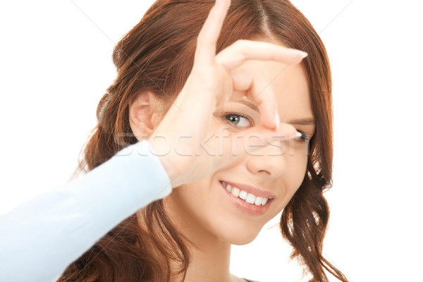 lovely woman looking through hole from fingers Stock photo © dolgachov