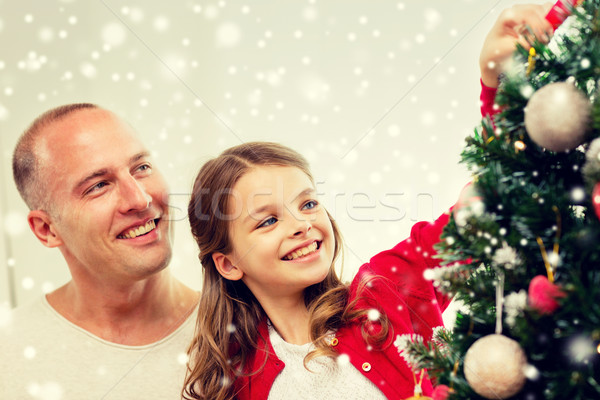 smiling family decorating christmas tree at home Stock photo © dolgachov