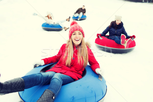 group of happy friends sliding down on snow tubes Stock photo © dolgachov