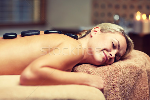 close up of woman having hot stone massage in spa Stock photo © dolgachov