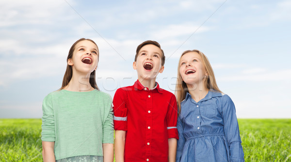 amazed boy and girls looking up Stock photo © dolgachov