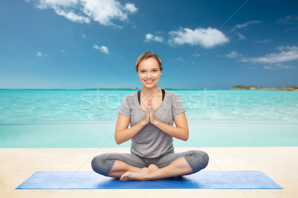 woman making yoga meditation in lotus pose on mat Stock photo © dolgachov