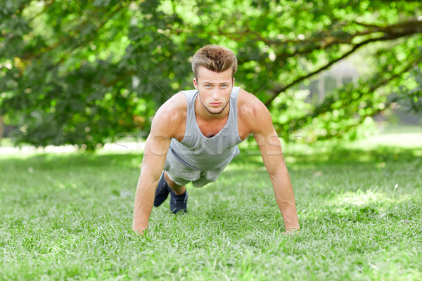 Młody człowiek pompek trawy lata parku fitness Zdjęcia stock © dolgachov