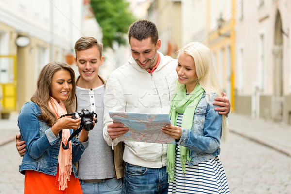 group of smiling friends with map and photocamera Stock photo © dolgachov